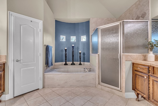 bathroom featuring lofted ceiling, a garden tub, a shower stall, and tile patterned flooring