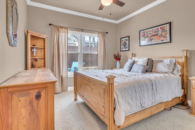 bedroom featuring ceiling fan, baseboards, crown molding, and light colored carpet