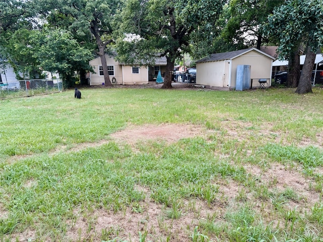 view of yard with an outbuilding, a shed, and fence