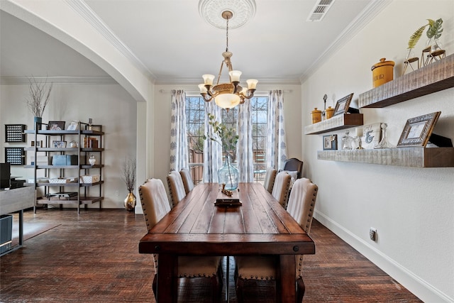 dining space featuring visible vents, arched walkways, dark wood-style floors, crown molding, and a chandelier