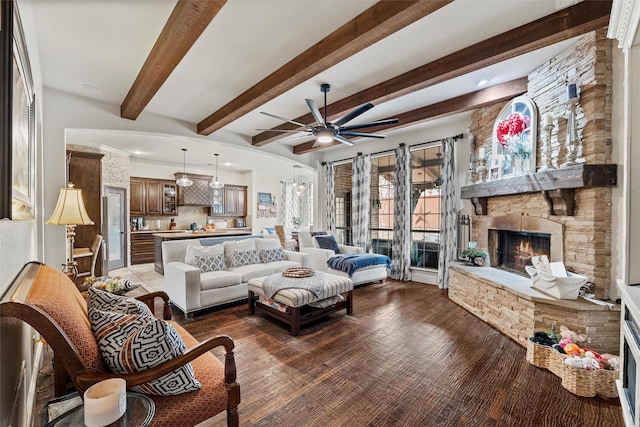 living room with ceiling fan, a fireplace, dark wood-style flooring, and beamed ceiling