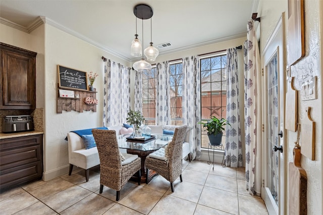 dining room with ornamental molding, light tile patterned flooring, visible vents, and baseboards