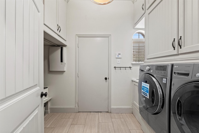 laundry room with cabinet space, washer and clothes dryer, and baseboards