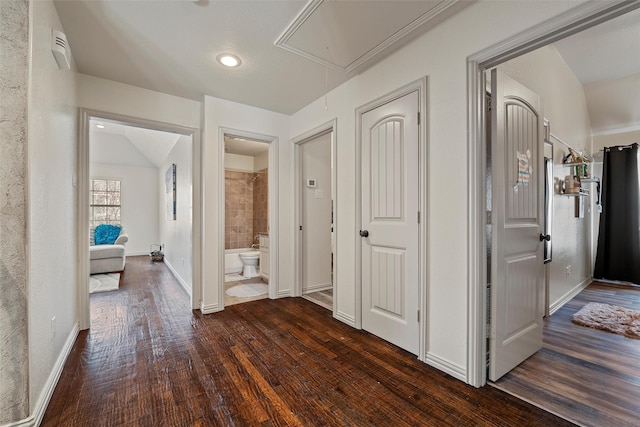 hallway with dark wood-style flooring, attic access, and baseboards