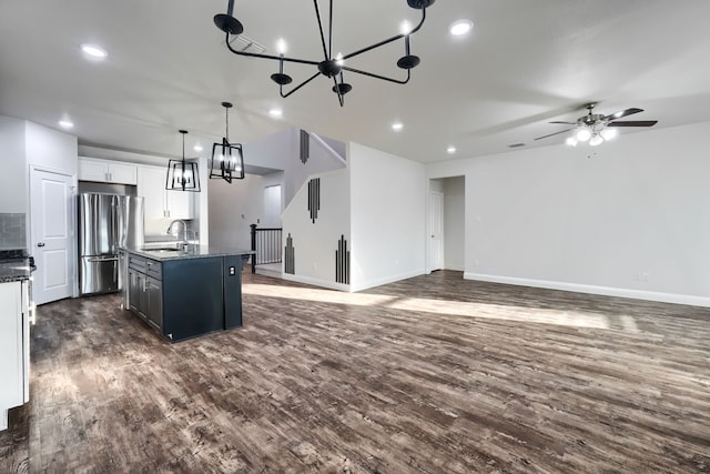 kitchen featuring white cabinets, a center island with sink, and open floor plan