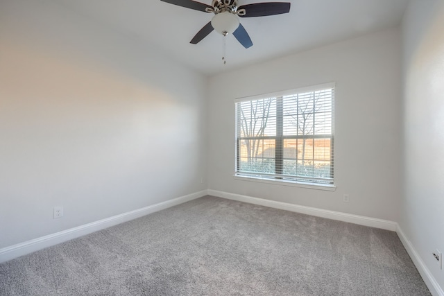 empty room featuring carpet floors, a ceiling fan, and baseboards