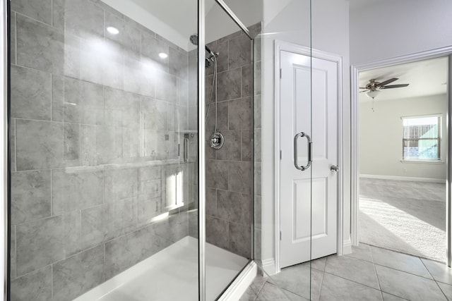 bathroom featuring tile patterned floors, a shower stall, a ceiling fan, and baseboards