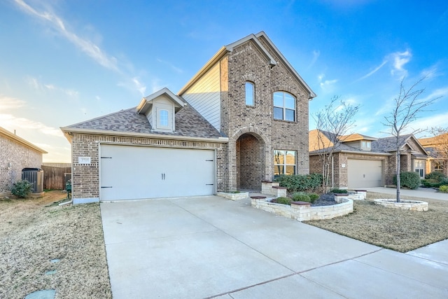 view of front of home with a garage, concrete driveway, roof with shingles, cooling unit, and brick siding