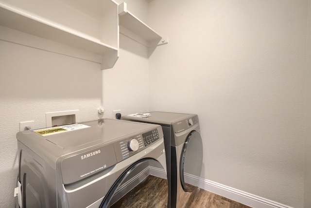 laundry room featuring dark wood-style floors, washing machine and dryer, laundry area, and baseboards