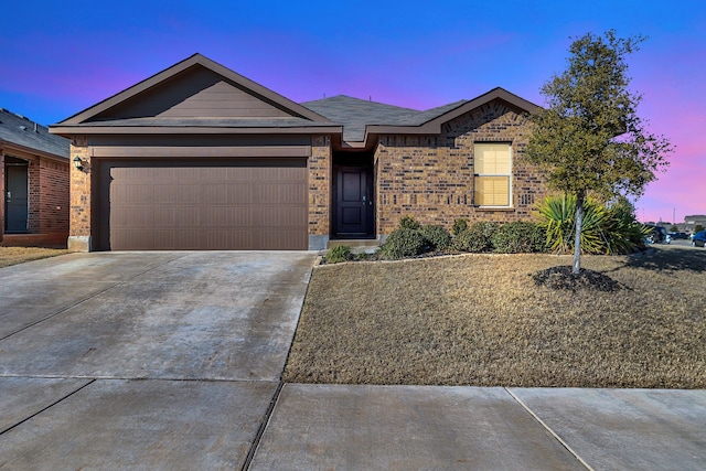 ranch-style home with a garage, concrete driveway, and brick siding