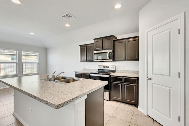 kitchen with light tile patterned floors, visible vents, appliances with stainless steel finishes, a kitchen island with sink, and a sink