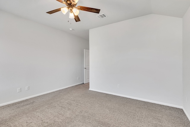 carpeted empty room with vaulted ceiling, visible vents, ceiling fan, and baseboards