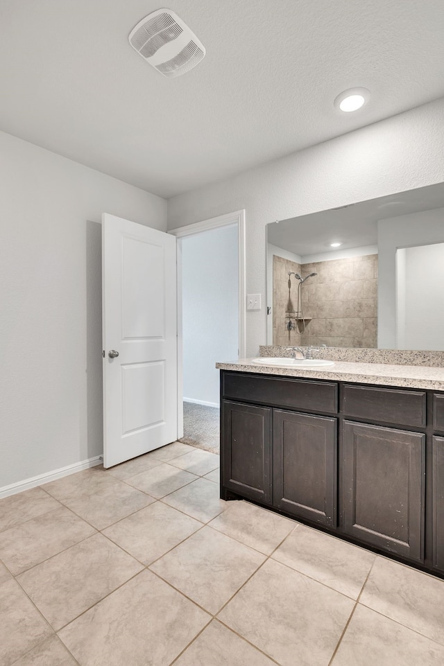 full bath with vanity, baseboards, visible vents, a tile shower, and tile patterned floors