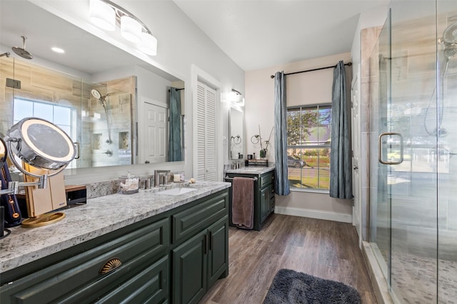 full bath featuring a stall shower, baseboards, wood finished floors, and vanity