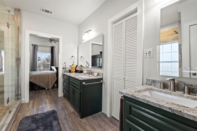 full bathroom with a stall shower, a closet, a sink, and wood finished floors