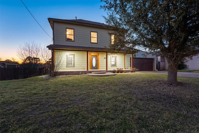 traditional home with driveway, an attached garage, fence, and a front yard