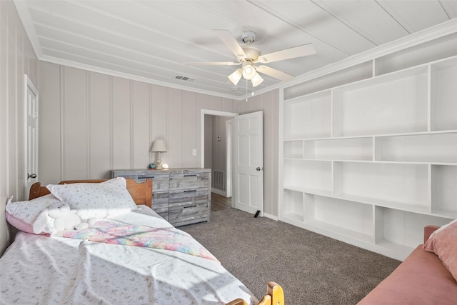 carpeted bedroom featuring a ceiling fan, visible vents, and crown molding