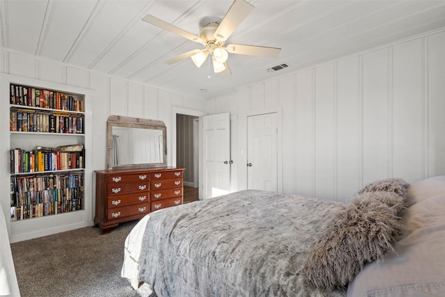 bedroom with a ceiling fan, visible vents, a decorative wall, and carpet flooring