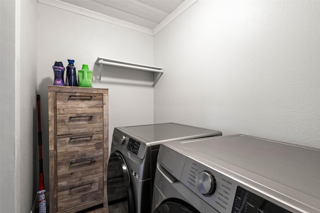 laundry room featuring laundry area, washing machine and clothes dryer, and crown molding