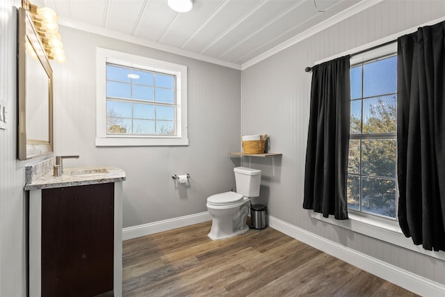 half bathroom featuring a wealth of natural light, wood finished floors, and toilet