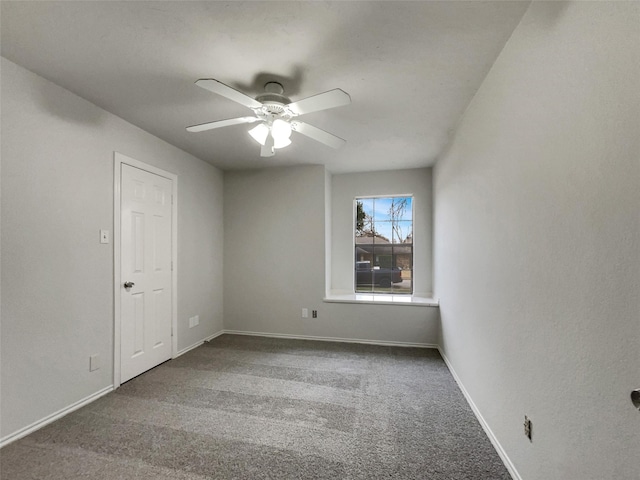 empty room with carpet, a ceiling fan, and baseboards