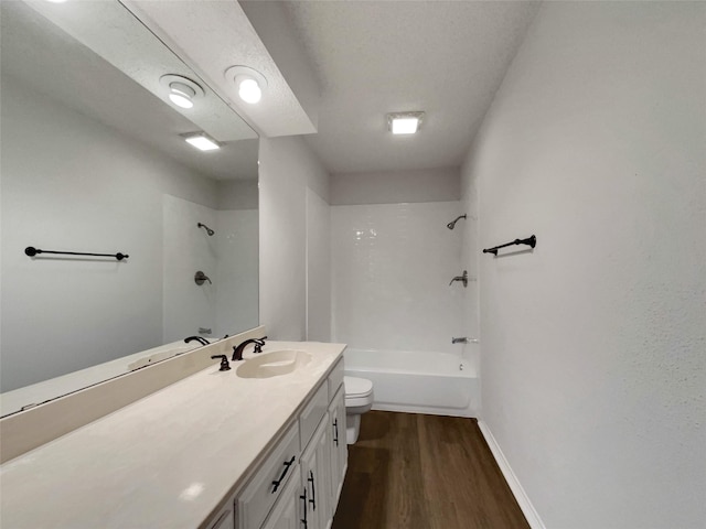 full bath with baseboards, toilet, wood finished floors, bathtub / shower combination, and vanity