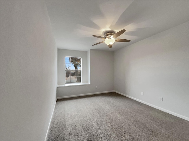 spare room with carpet flooring, a ceiling fan, and baseboards