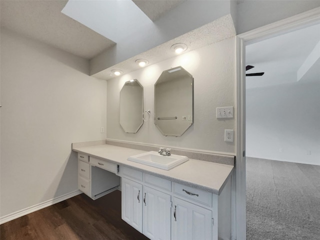 bathroom with baseboards, wood finished floors, and vanity