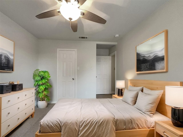 carpeted bedroom featuring a ceiling fan and visible vents