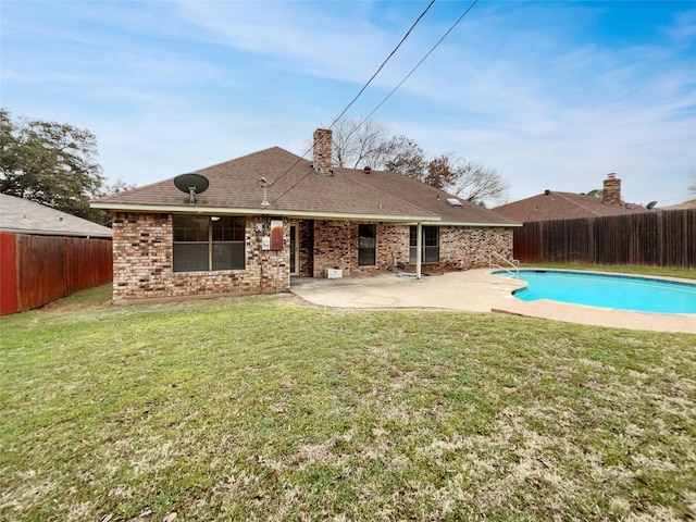 rear view of property with a fenced in pool, brick siding, a lawn, a patio area, and a fenced backyard