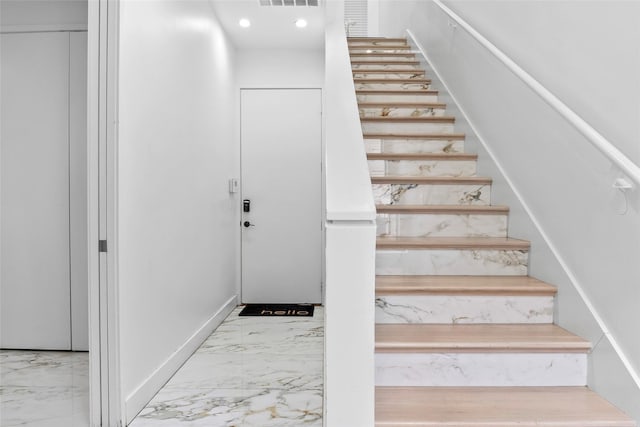 staircase featuring marble finish floor, visible vents, and recessed lighting