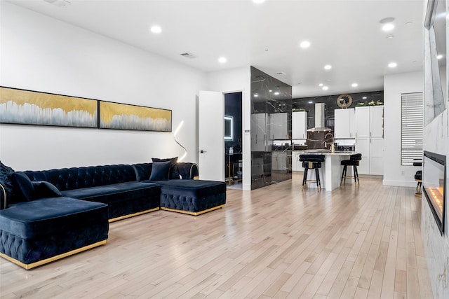 living area with light wood finished floors and recessed lighting