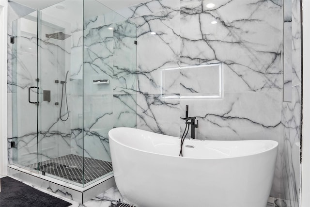 bathroom featuring a soaking tub and a marble finish shower