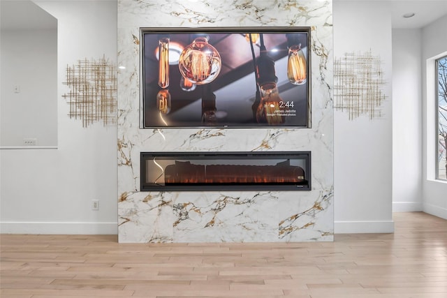 interior details with a fireplace, baseboards, and wood finished floors