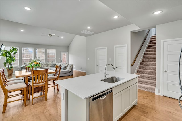 kitchen featuring a ceiling fan, light countertops, stainless steel dishwasher, light wood-style floors, and a sink