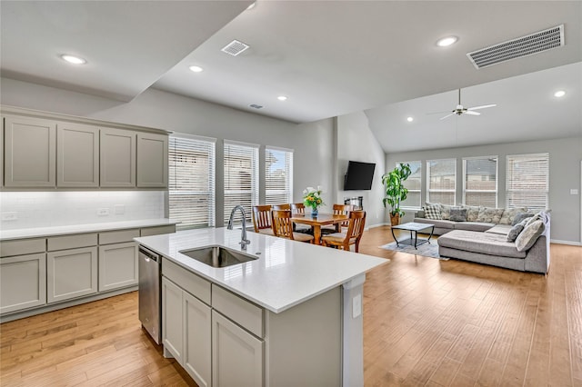 kitchen with dishwasher, a sink, visible vents, and gray cabinetry