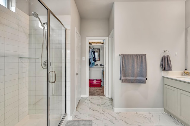 full bathroom featuring marble finish floor, a shower stall, and a spacious closet