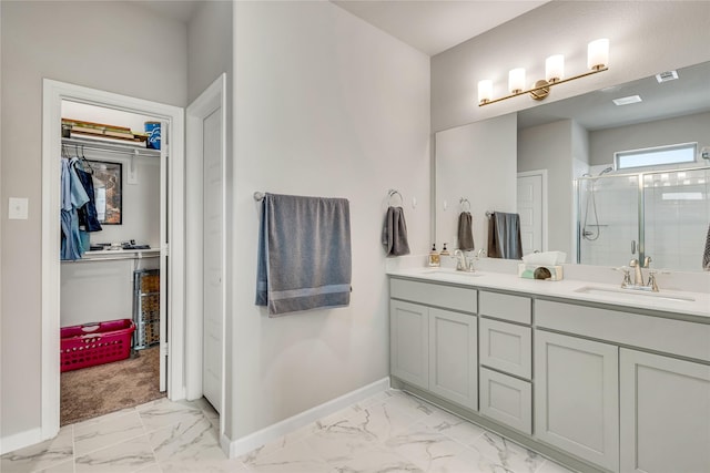 bathroom with marble finish floor, a stall shower, a sink, and baseboards