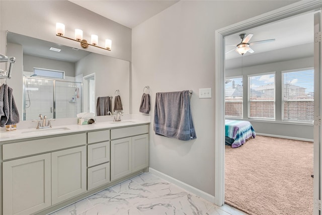 full bath featuring baseboards, ceiling fan, marble finish floor, a shower stall, and a sink