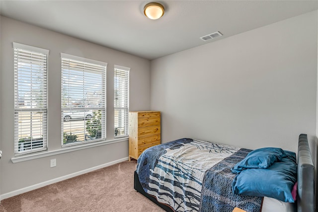 carpeted bedroom featuring visible vents and baseboards