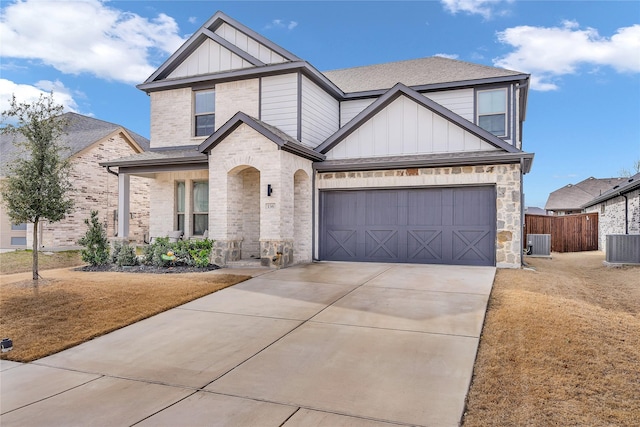 view of front facade featuring concrete driveway, an attached garage, central AC unit, board and batten siding, and fence