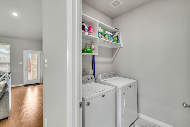 washroom with washing machine and dryer, laundry area, visible vents, and baseboards