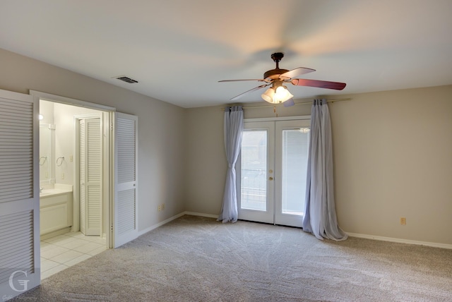 unfurnished bedroom with baseboards, light colored carpet, ensuite bathroom, access to exterior, and french doors