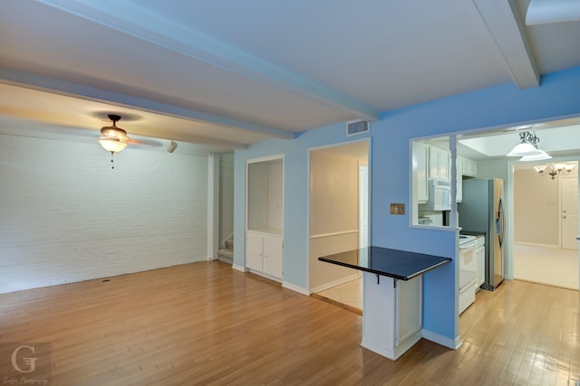 kitchen featuring beam ceiling, light wood finished floors, visible vents, white appliances, and a peninsula