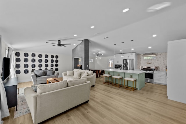 living room featuring ceiling fan, vaulted ceiling, light wood-style flooring, and recessed lighting