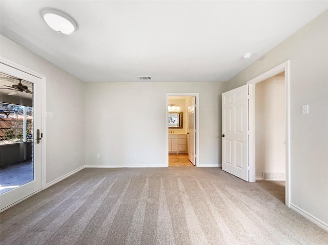 unfurnished bedroom featuring light carpet, visible vents, baseboards, and ensuite bathroom