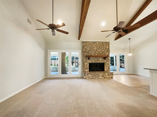 unfurnished living room featuring high vaulted ceiling, beamed ceiling, a fireplace, and a wealth of natural light