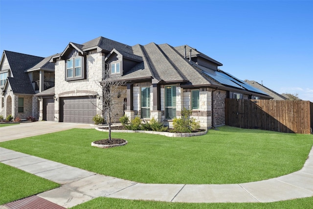 view of front facade featuring stone siding, fence, a front lawn, and concrete driveway