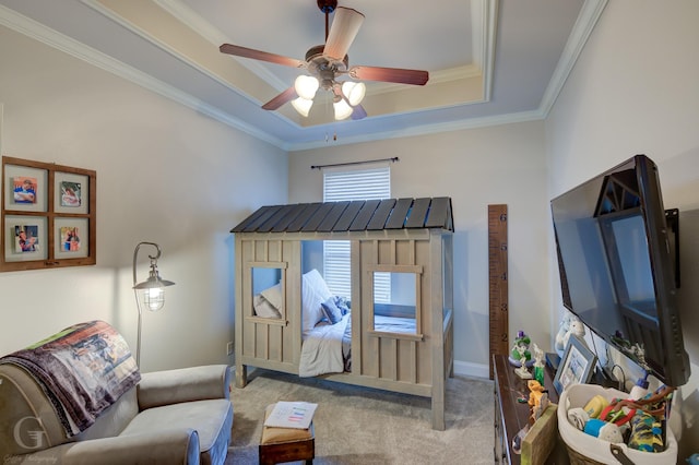 bedroom featuring ceiling fan, light colored carpet, baseboards, ornamental molding, and a tray ceiling