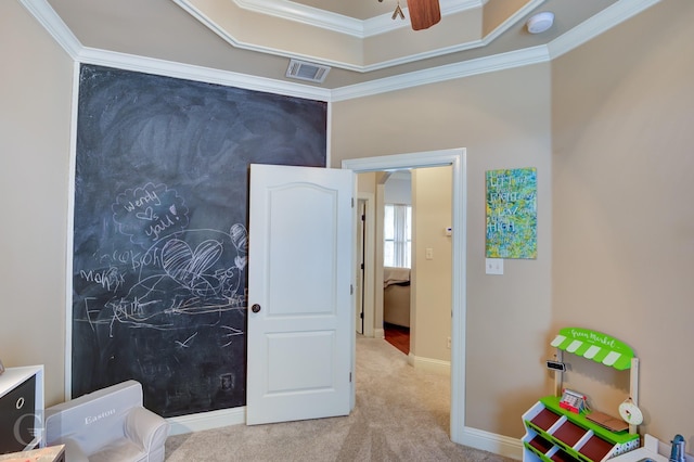 bedroom with baseboards, visible vents, a raised ceiling, light colored carpet, and ornamental molding